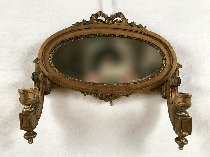Applique miroir en bois doré portant deux bougeoirs de style Louis XVI